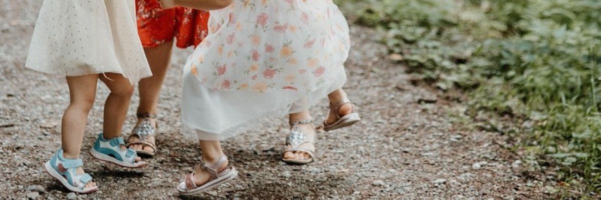 tanzende Füße von zwei Kindern und einer erwachsenen Person