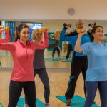 Männer und Frauen arbeiten mit Hanteln