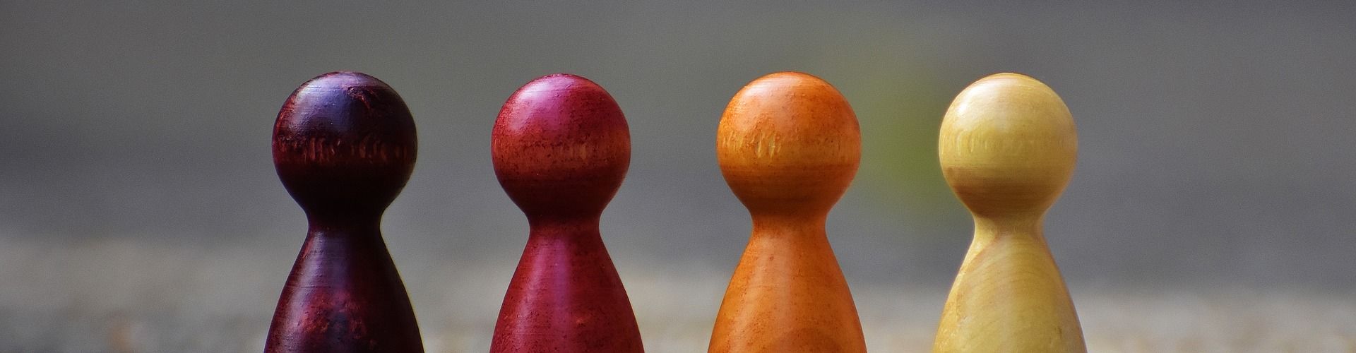 Vier bunte Spielfiguren in einer Reihe